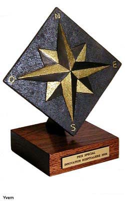 Trophée présentant un bas relief de Rose des Vents monté sur socle en bois verni et plaque dorée gravée